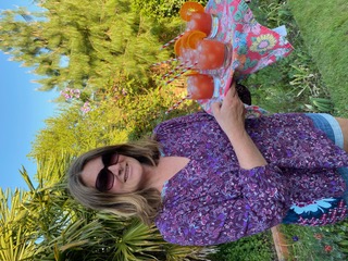 A Woman posing with drinks at garden
